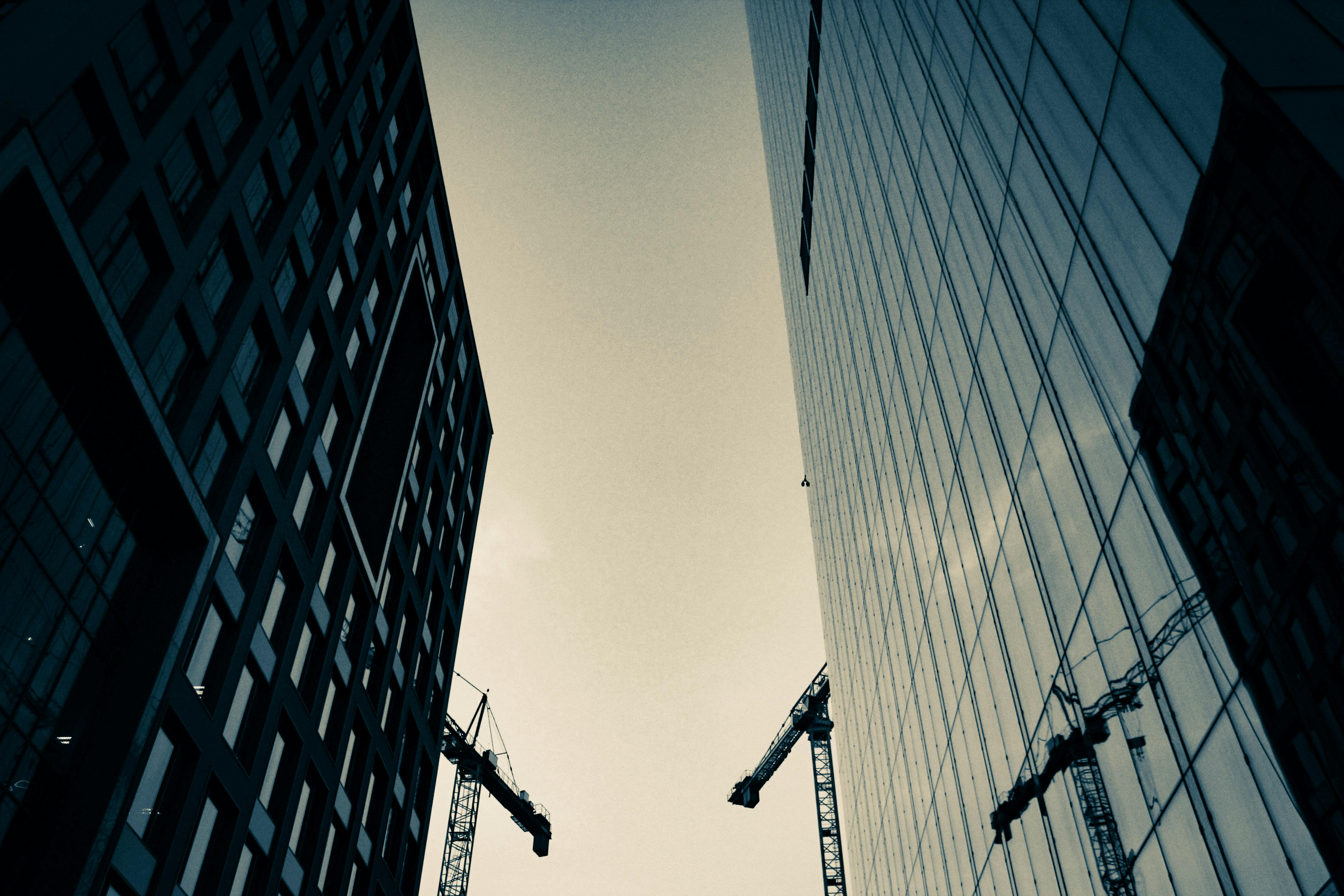 现代摩天大楼和起重机的剪影映衬在城市建设的背景中