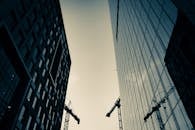 现代摩天大楼和起重机的剪影映衬在城市建设的背景中