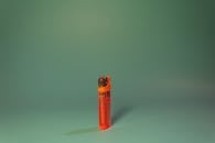 Orange Disposable Lighter on Green Surface