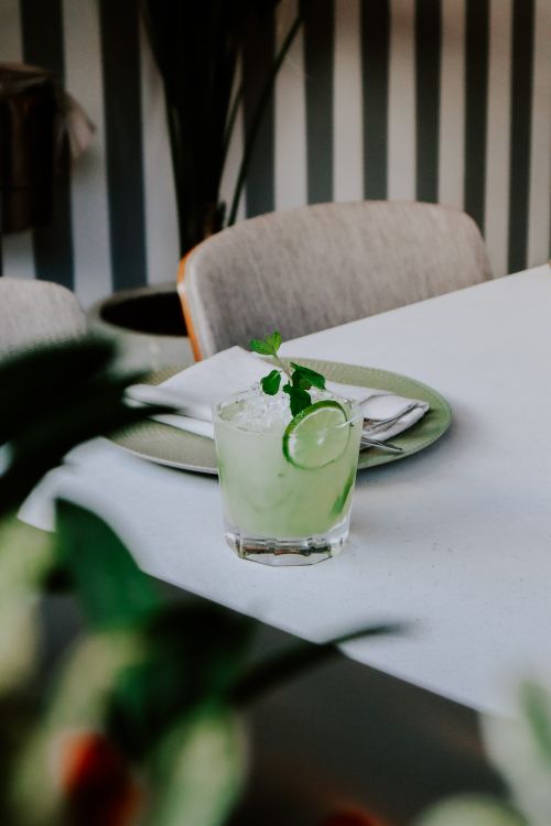 Free Close-up of a refreshing lime mojito cocktail on a dining table with mint garnish. Stock Photo