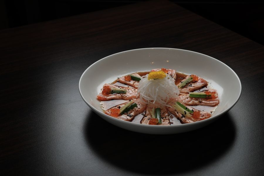 Tiradito nikkei con salsa de sillao, sesamo tostado y cebolla china