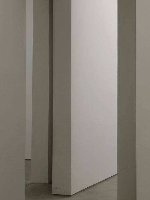 Free A minimalist interior space showcasing geometric white walls and subtle shadows. Stock Photo