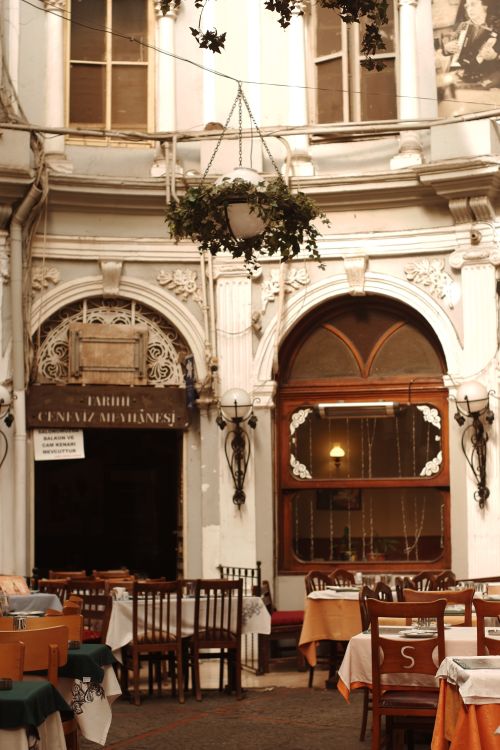 Free A beautifully set outdoor dining space with historic architectural details and hanging plants. Stock Photo