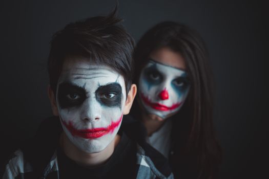 Dramatic portrait of individuals with Joker-inspired face paint, perfect for Halloween themes.