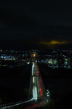 Stunning aerial view of a city at night with vibrant light trails and illuminated skyline.