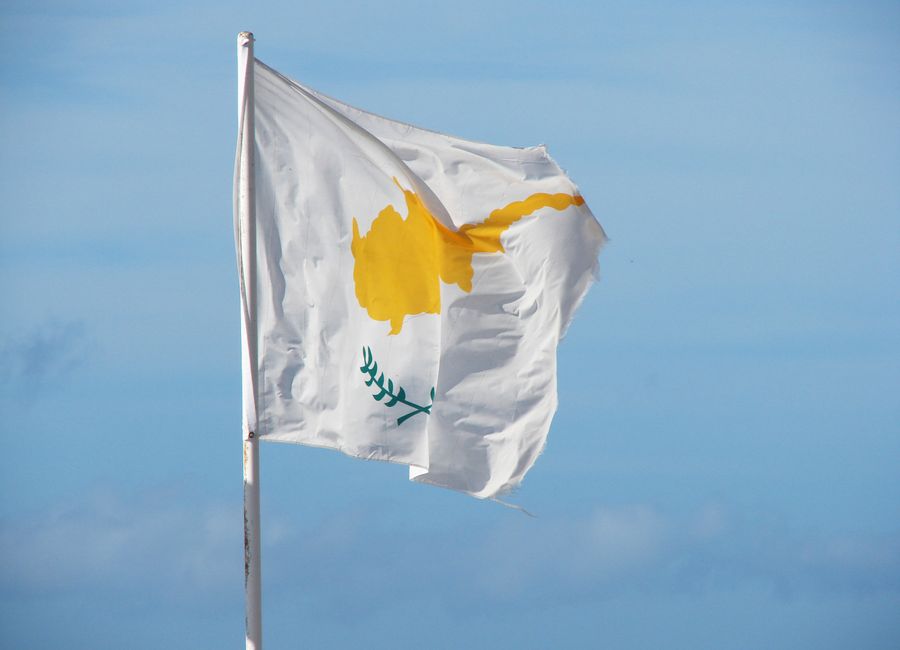 The national flag of Cyprus waving in the breeze against a clear blue sky.