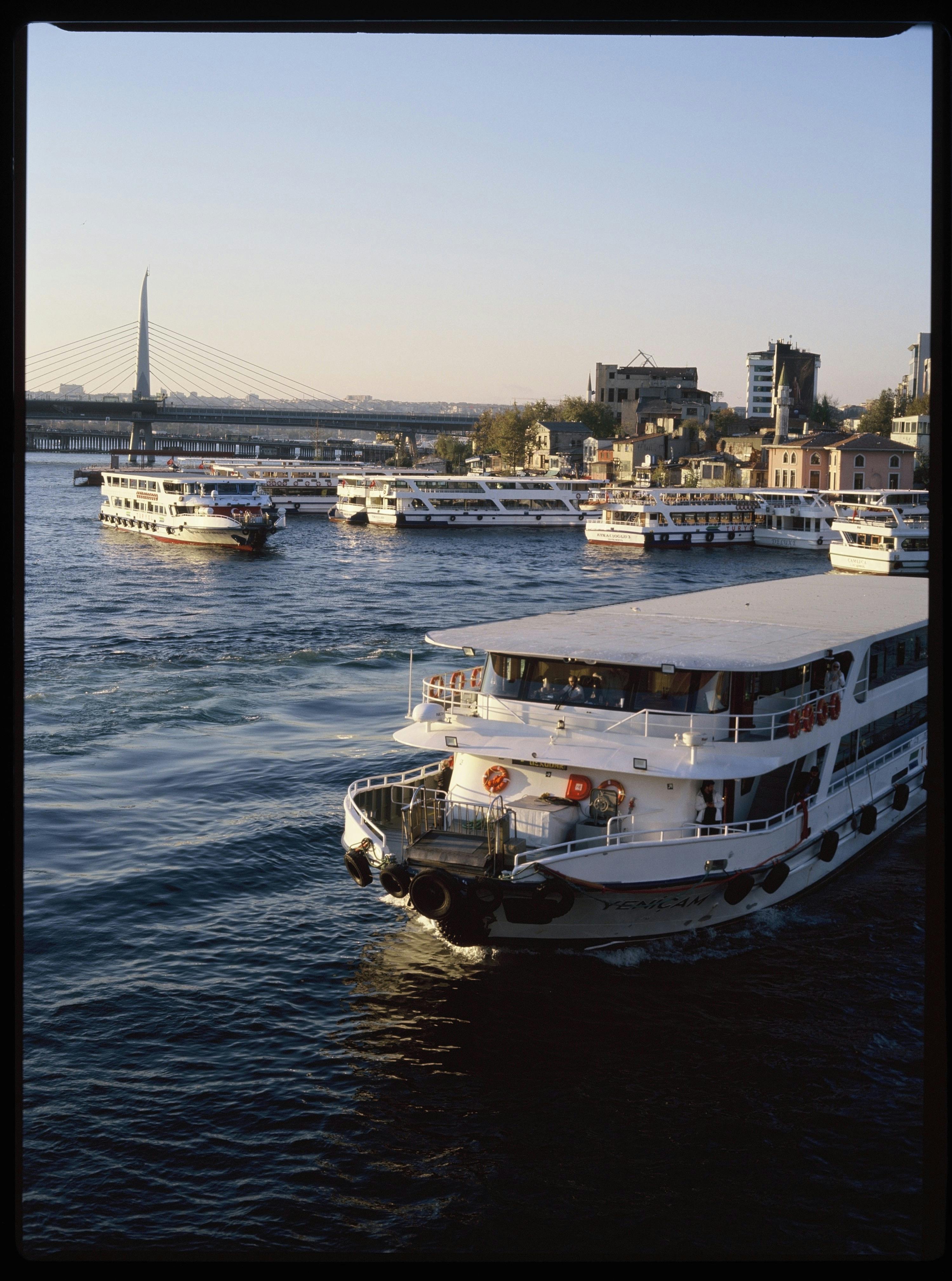 Ferries cruising the Golden Horn in İstanbul with a scenic city backdrop during dusk.