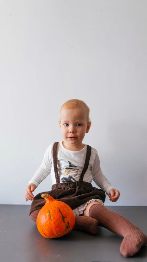 A Boy in White Long Sleeve Shirt Wearing Brown Socks