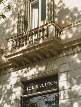 Charming architectural detail with balcony at iconic Louis Vuitton store, Barcelona.