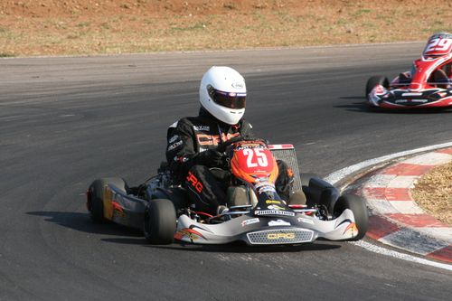 Free Energetic go-kart racers in action on an outdoor race track during a thrilling competition. Stock Photo