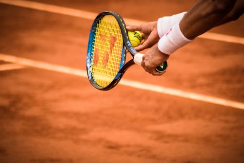 Foto Del Primo Piano Della Persona Che Tiene La Racchetta E La Palla Da Tennis