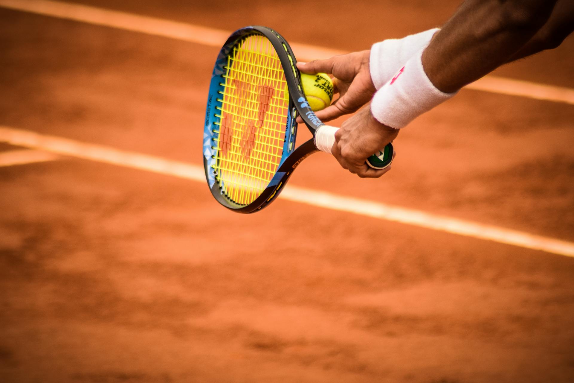 Close-Up Photo of Person Holding Tennis Racket and Ball