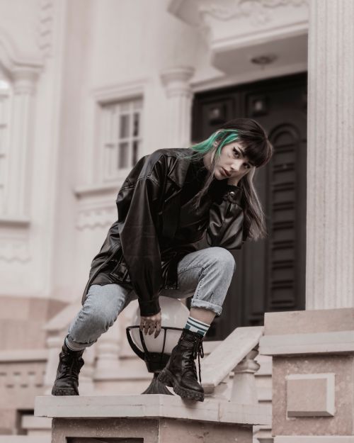 Free Stylish young woman in a leather jacket poses on city steps, capturing urban fashion vibes in Iran. Stock Photo