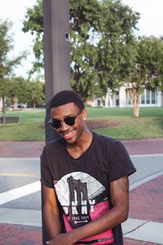 在弗吉尼亚州威廉斯堡的公园里，一位戴着墨镜的休闲年轻人微笑着