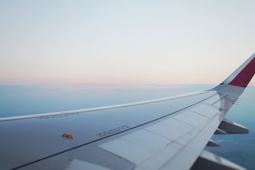 Free A tranquil view of an airplane wing against a pastel sky, symbolizing travel and freedom. Stock Photo