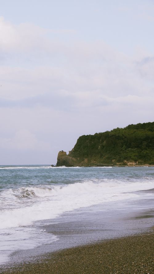 Free A serene beach with waves crashing against the Zonguldak shoreline under a soft sky. Stock Photo