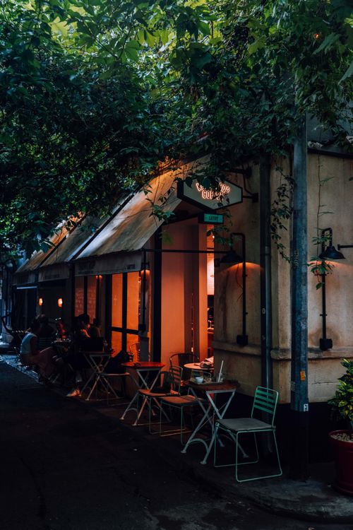 Free Dimly lit café entrance in a quiet street of Istanbul, Turkey, with outdoor seating. Stock Photo