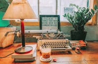 这个复古工作空间很舒适，配有打字机、台灯和冰咖啡
