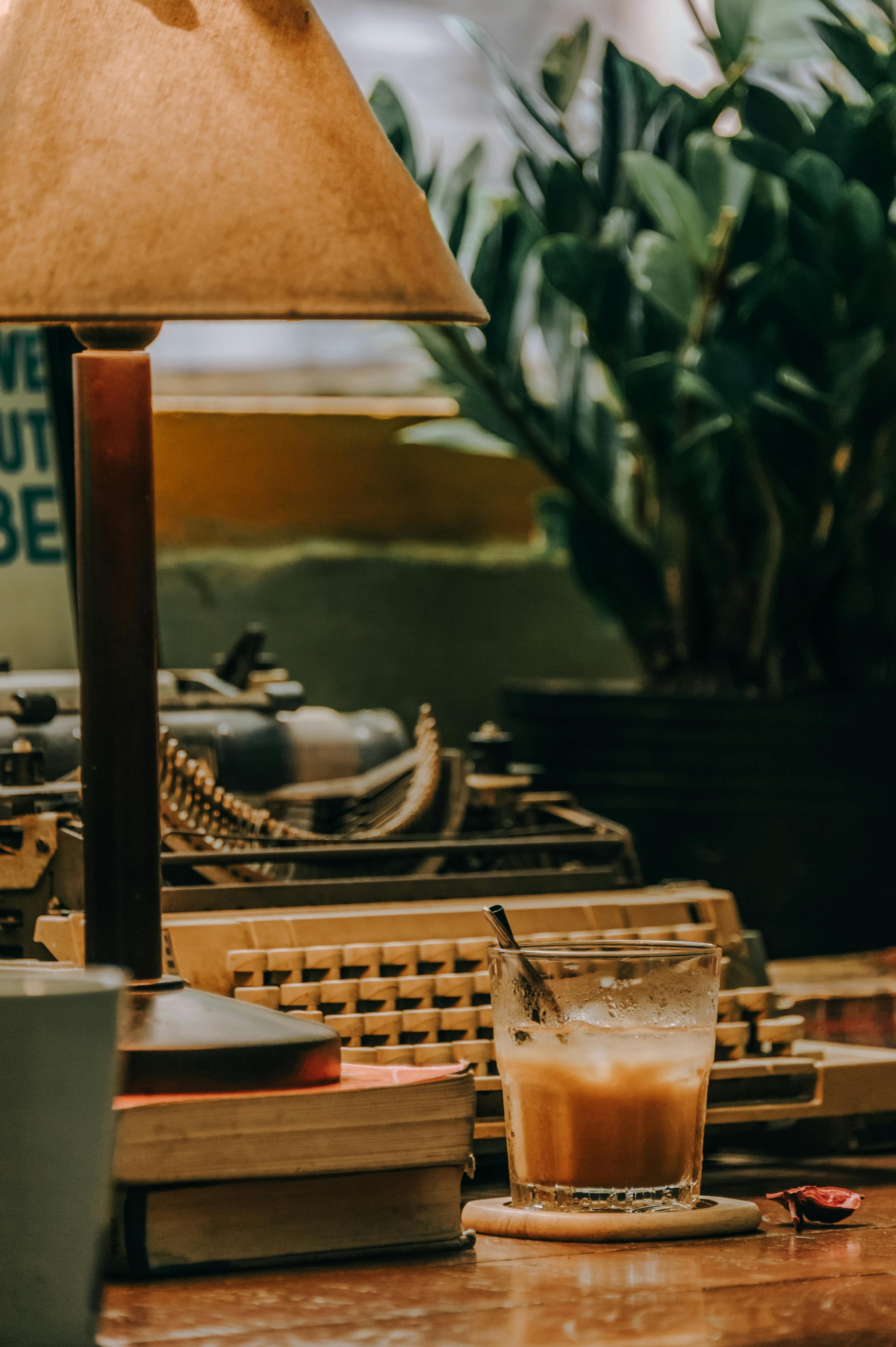 工作空间温暖而复古，木桌上放着一台打字机和一杯咖啡