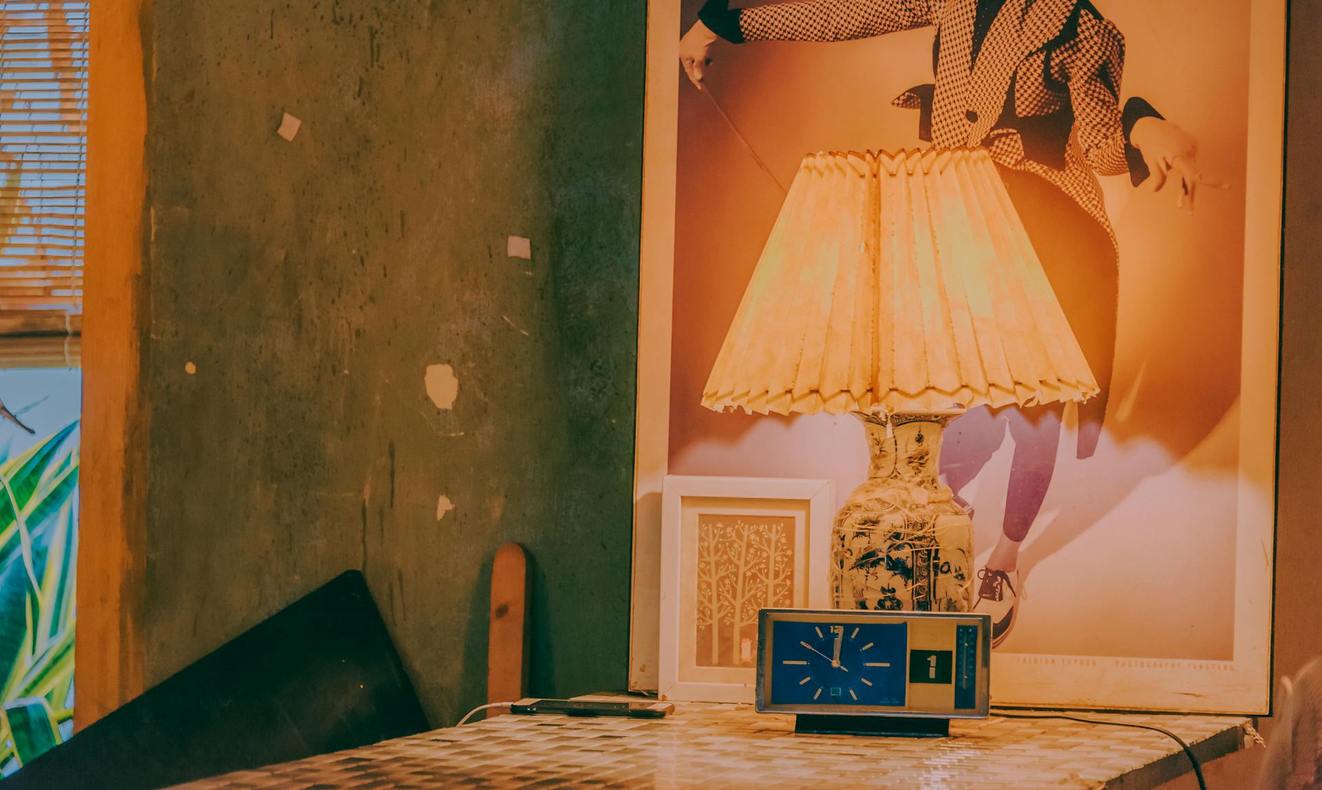 Warm and nostalgic interior featuring a vintage lamp and clock against a textured wall.