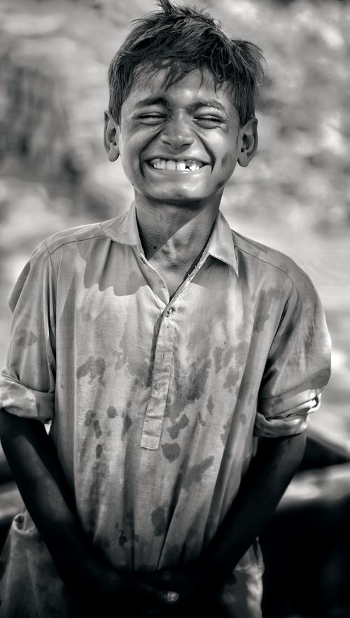 Free A young boy in a collared shirt smiles broadly, exuding pure joy and innocence. Stock Photo