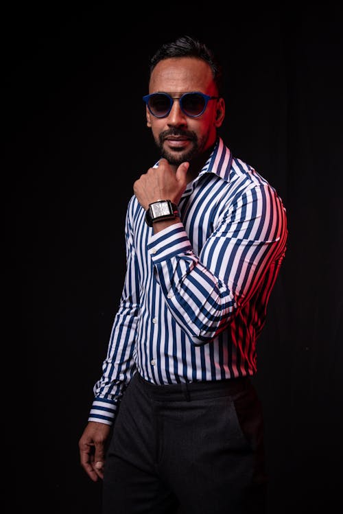 Man in Striped Long Sleeves Wearing Sunglasses on Black Background