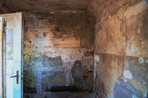 Free Explore the rustic beauty of an abandoned room with textured, decaying walls and a worn-out door. Stock Photo
