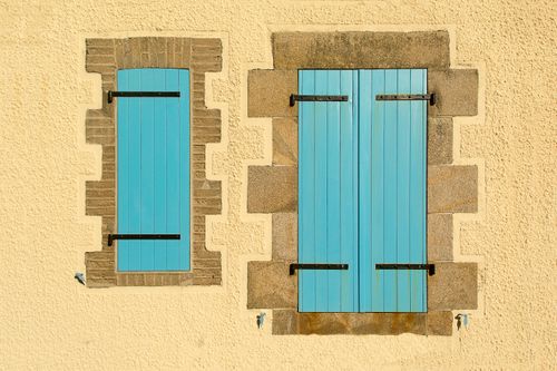 Free Elegant blue wooden shutters on a rustic stone wall, perfect for architectural or vintage themes. Stock Photo
