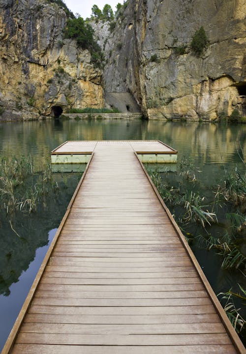 A Wooden Pier on a Lake Surrounded by Mountains 