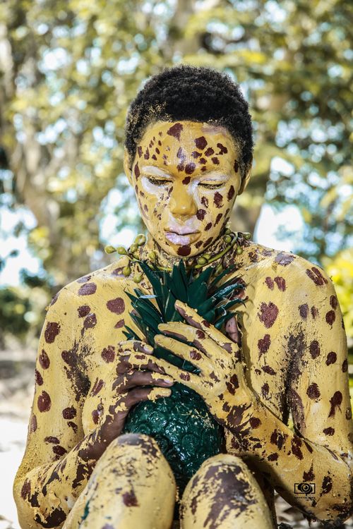 Free A creative portrayal of a person painted artistically holding a pineapple in Tanzania. Stock Photo