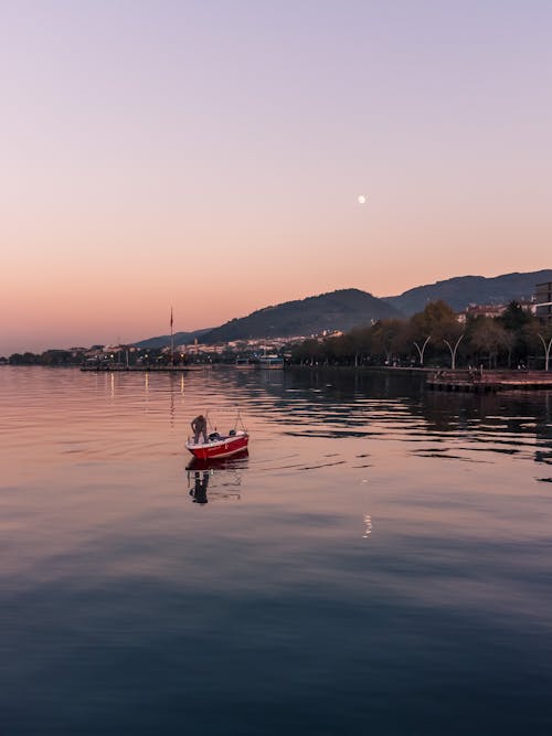 Fisherman on a Red Boat Anchored on Sea