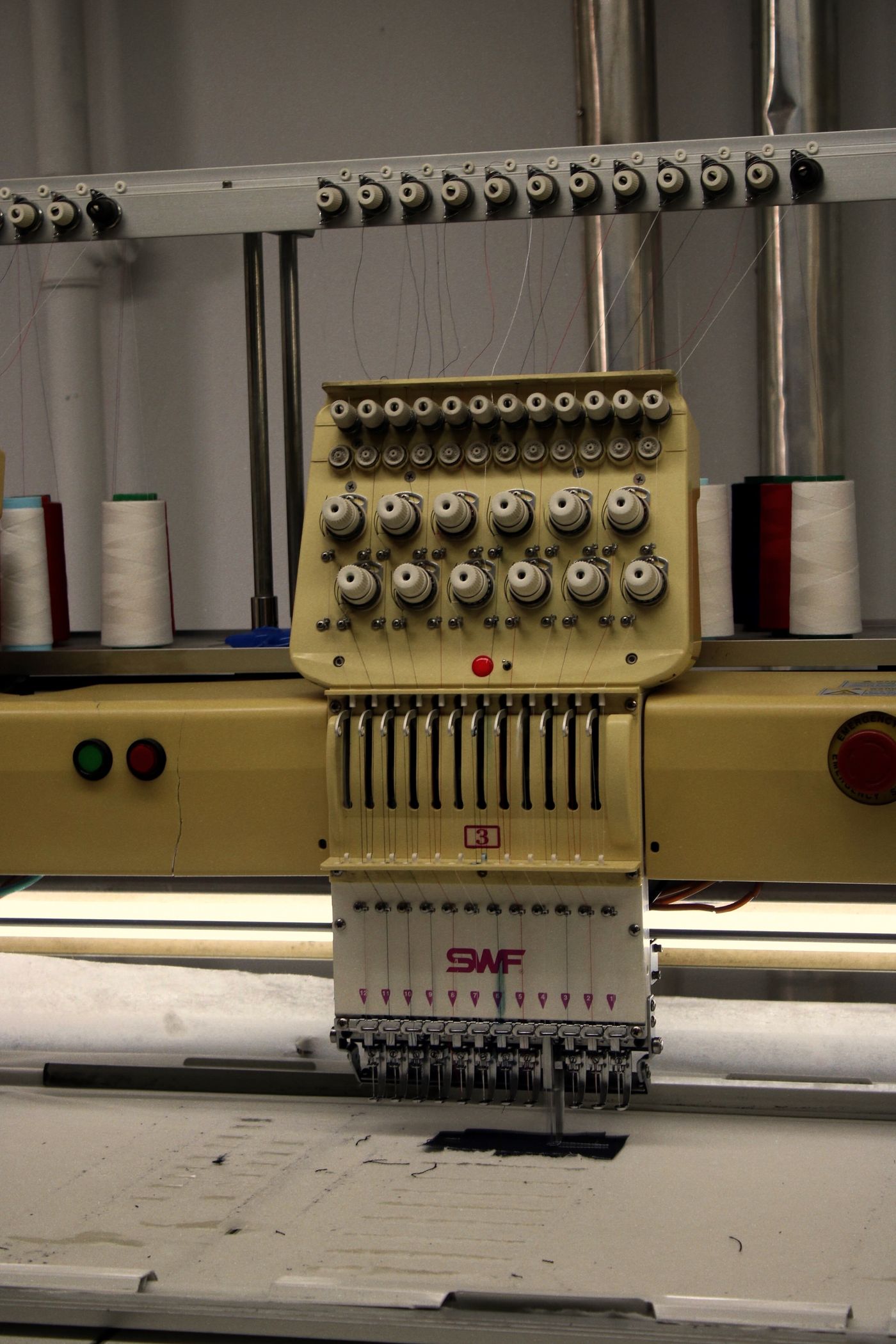 Equipo industrial de confección y detalle de hilos en máquina textil