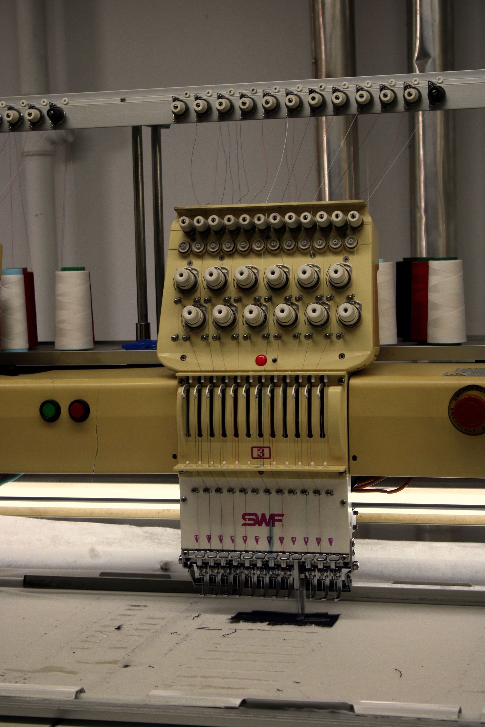 Industrial embroidery machine with colorful thread spools