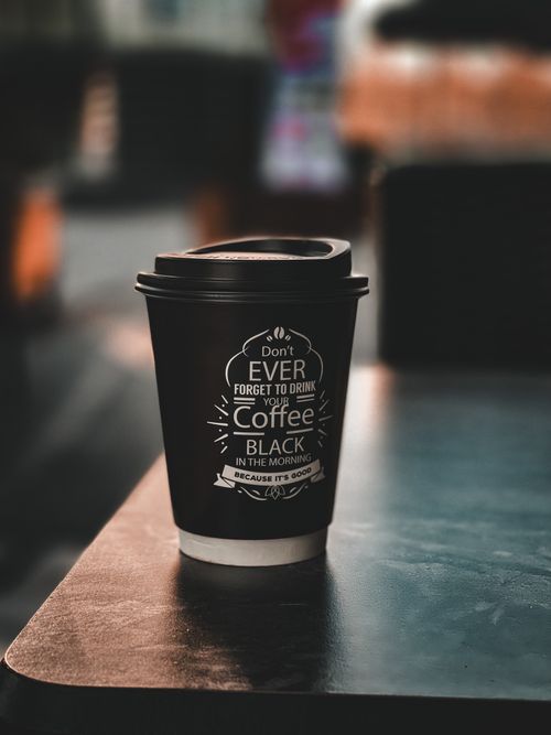 Free A stylish disposable coffee cup with an inspirational message on a table in Istanbul. Stock Photo