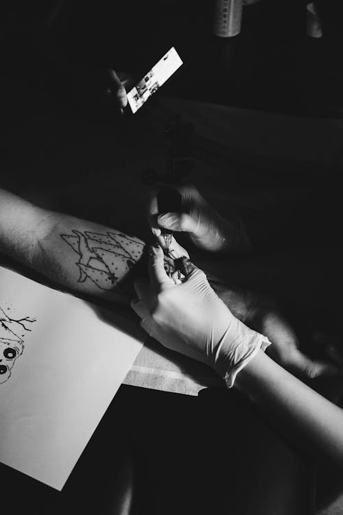 Человек делает сеанс татуировки