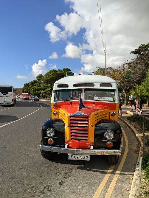 Free Colorful vintage bus on a road in Mdina, Malta, showcasing nostalgia and transportation history. Stock Photo