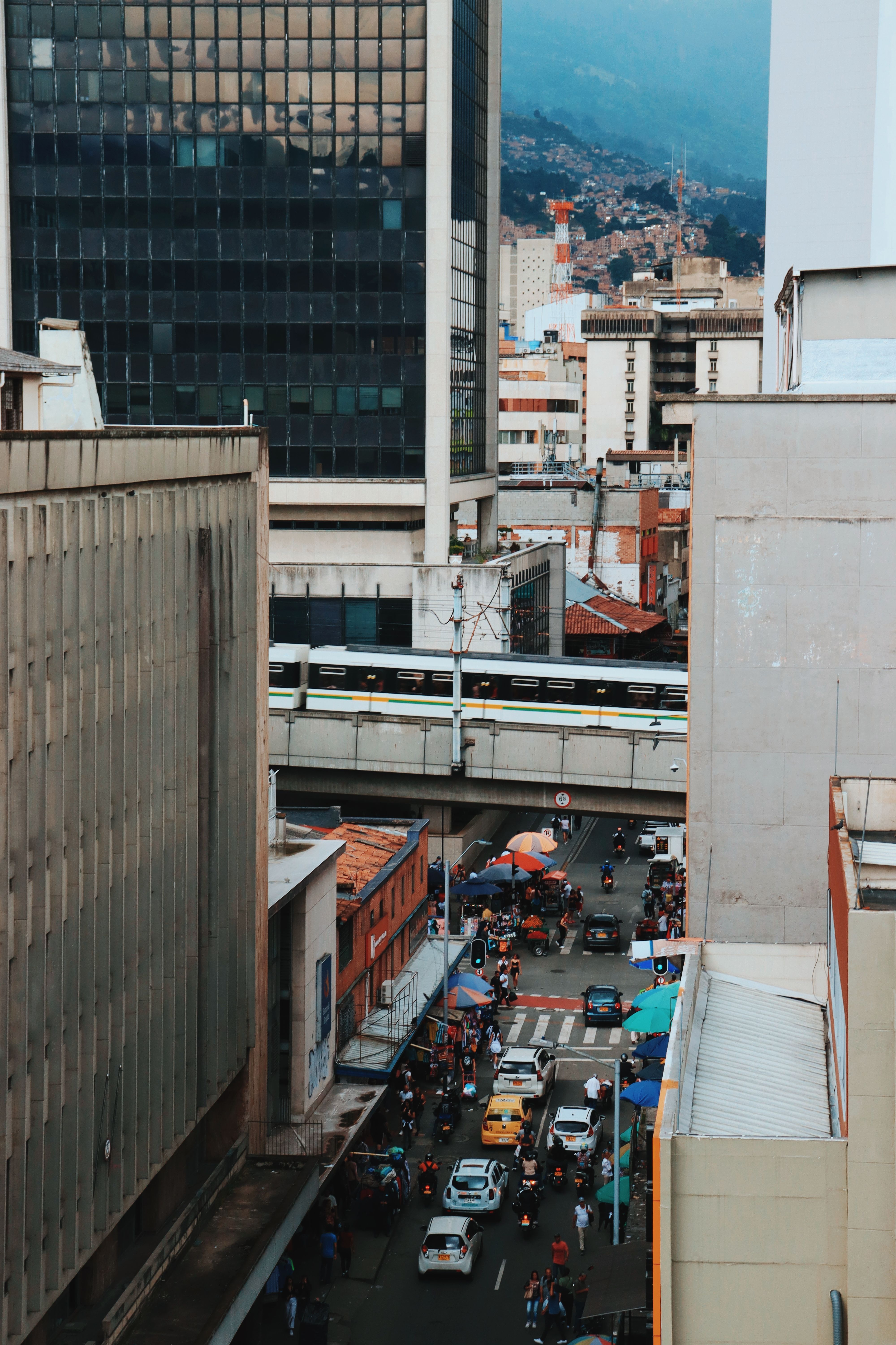 A vibrant street view of downtown Medellín, showcasing busy city life with tall buildings and traffic.
