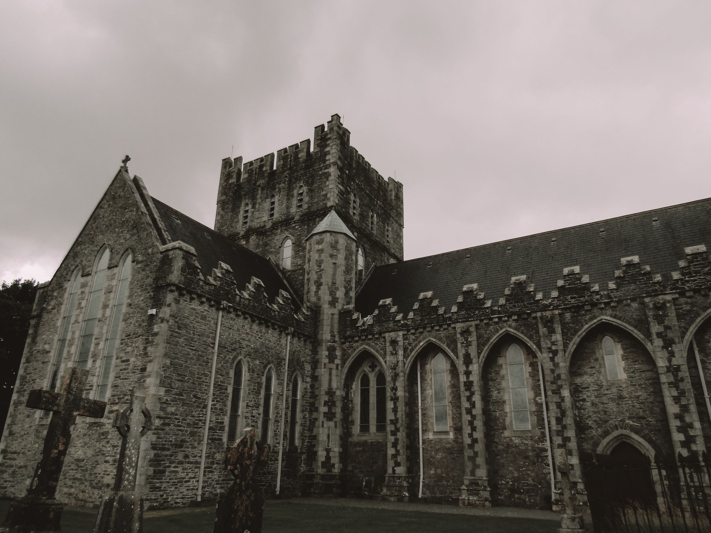 Historic gothic cathedral exterior with cloudy sky in Ireland, showcasing detailed architecture