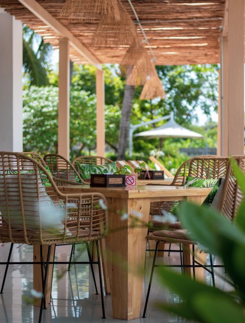 Free Inviting patio dining set in a resort surrounded by lush greenery, perfect for summer relaxation. Stock Photo