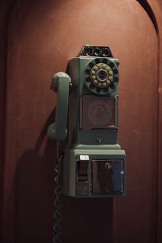 Retro wall-mounted telephone with rotary dial, evokes nostalgia and vintage elegance.