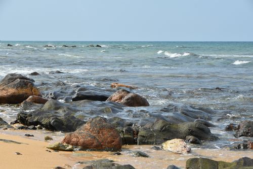Free Natural rocky shoreline with waves on a sunny day. Stock Photo