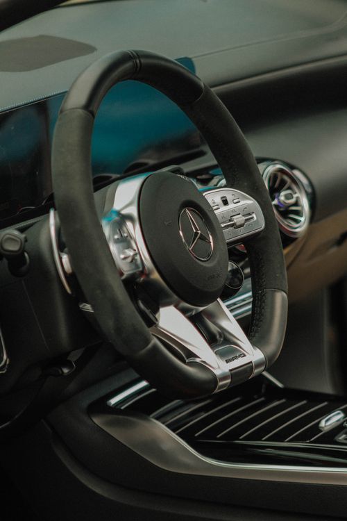Free Close-up of a modern luxury car steering wheel and dashboard. Perfect for automotive themes. Stock Photo