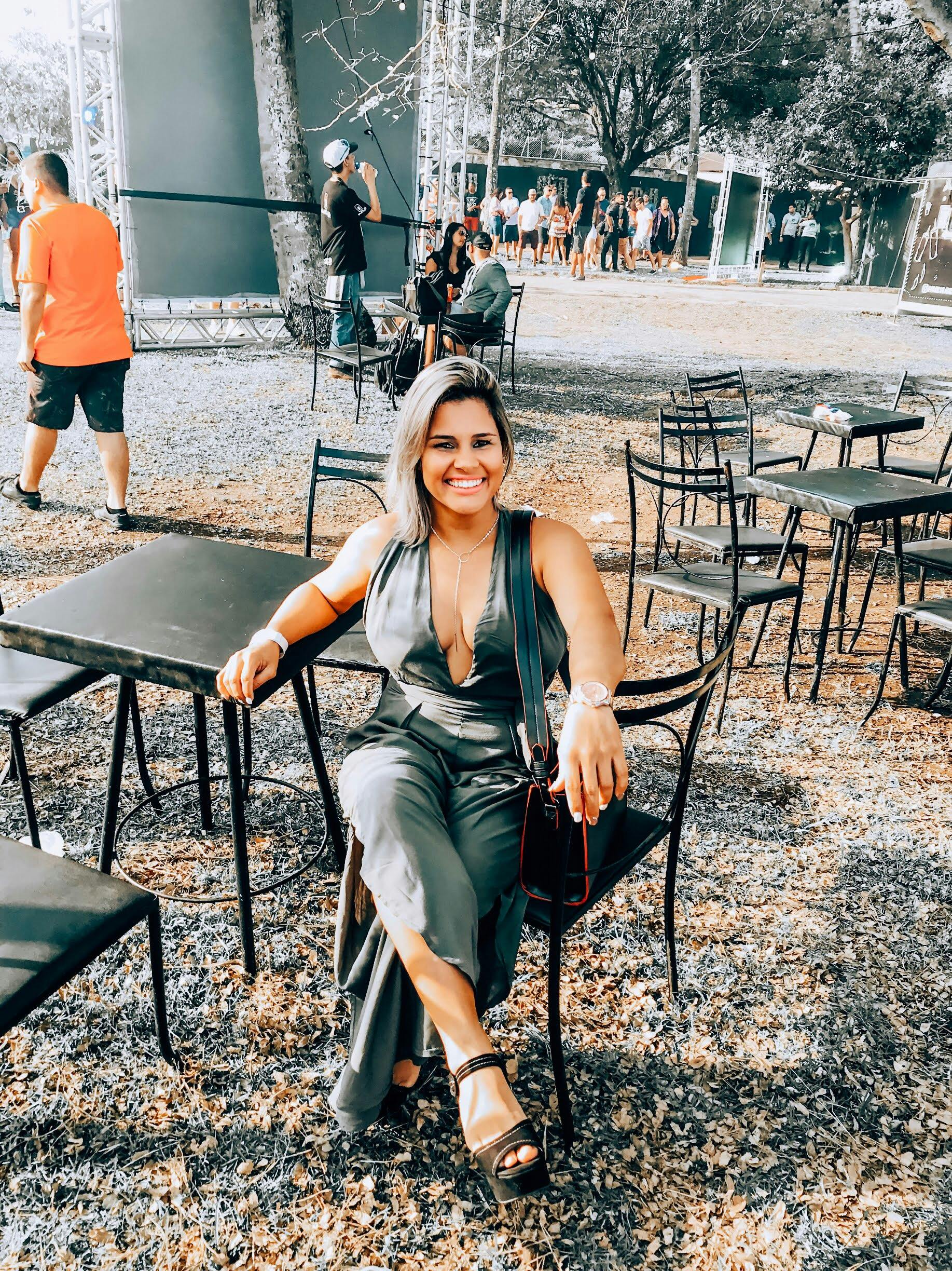 一位时尚女士自信地坐在公园外的椅子和树木之间，散发着时尚与魅力