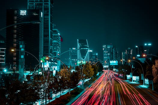 Dynamic night scene of Ankara with illuminated skyscrapers and colorful light trails.