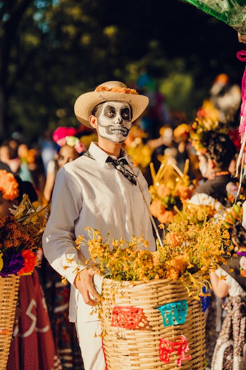 Man in Traditional Clothing Standing with Flowers for Dia de Muertos