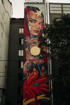 Stunning street art mural featuring a woman and abstract figures on an urban building wall.