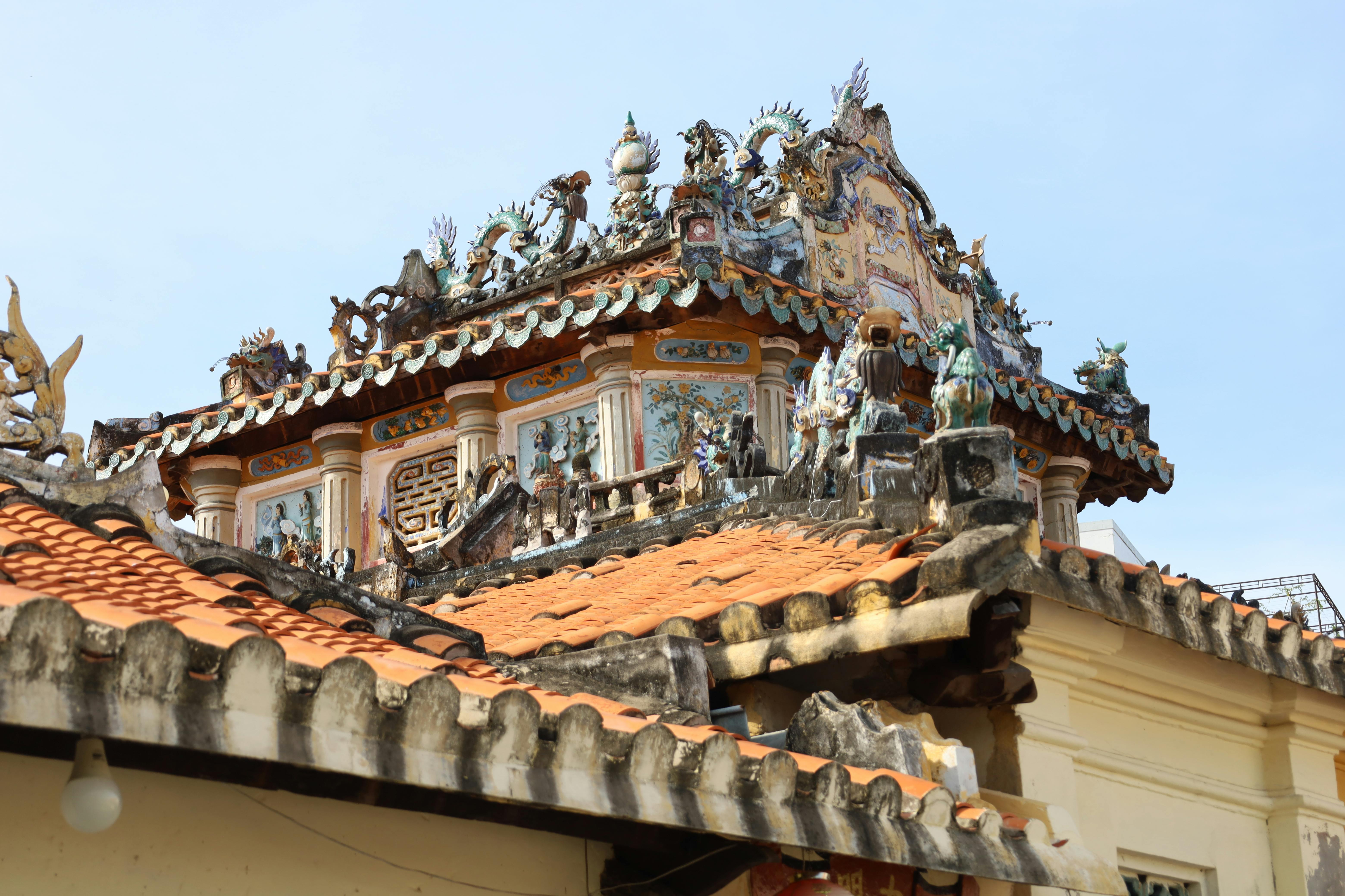 Detailed view of a dragon-adorned roof sculpture at an Asian temple.