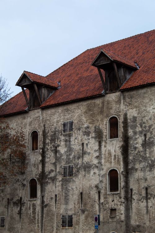 Free Vertical shot of an old, rustic building with arched windows and red tiled roof. Stock Photo