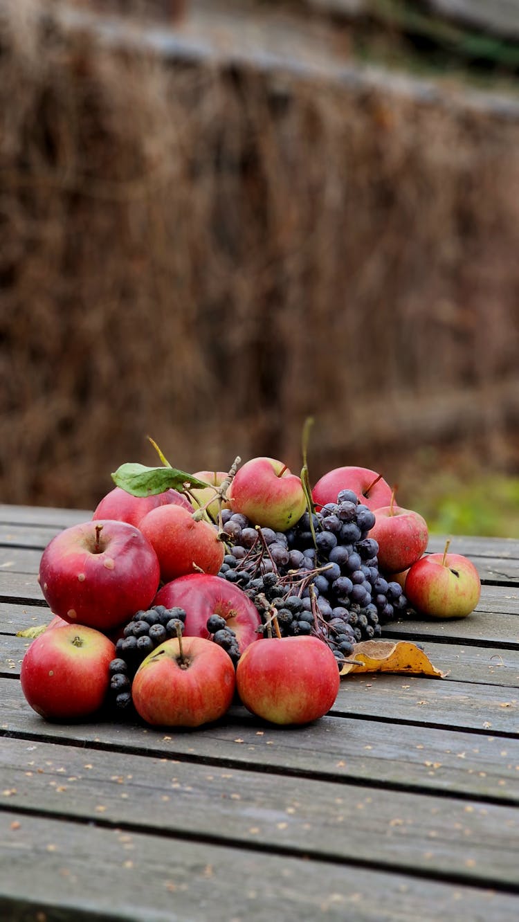 Photograph Of Grapes And Apples On A Wooden Surface