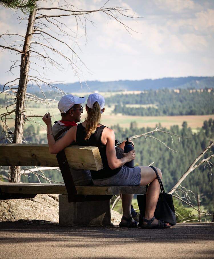 Photo Of A Man And A Woman Sitting On A Bench